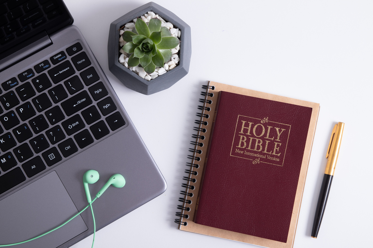 Bible and Laptop on the Work Table with Headphones. Bible Study Online